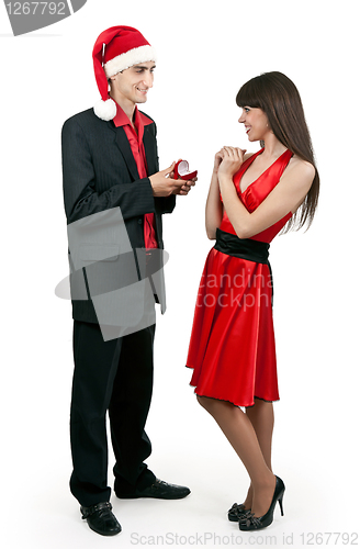Image of Man in Santa hat gives a woman a ring