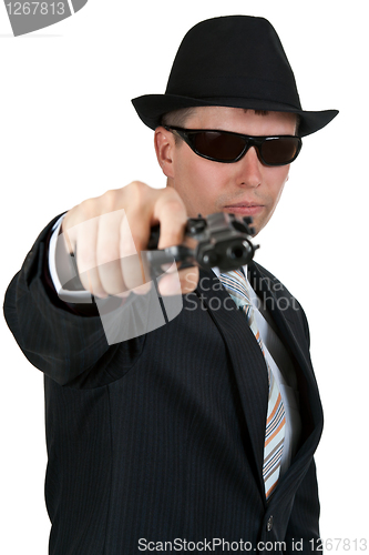 Image of businessman in a hat and sunglasses with a gun