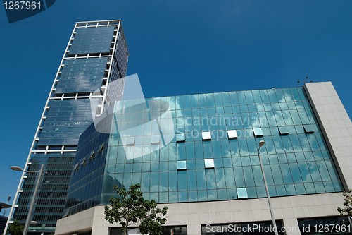 Image of Office buildings with clouds reflecting in the windows