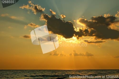 Image of Sun behind a cloud over sea