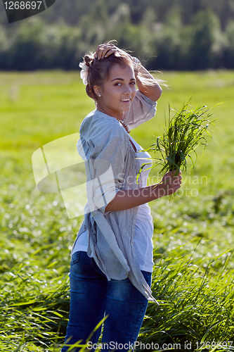 Image of girl with a bundle of green grass