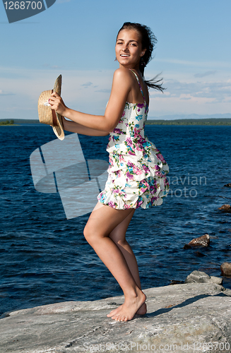 Image of girl with a straw hat standing