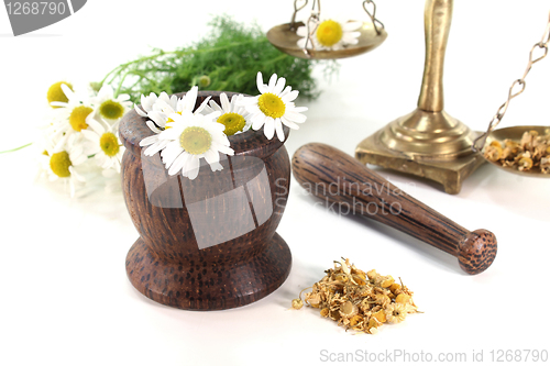 Image of chamomile flowers with mortar and scales