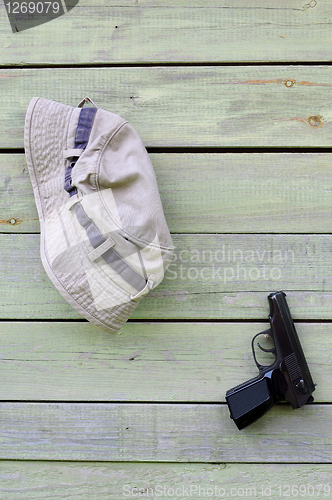 Image of Hat and Pistol on Shabby Wooden Wall