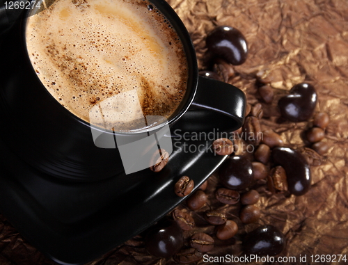 Image of Coffee with milk, coffee beans and chocolate dragees.