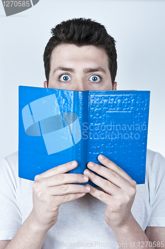 Image of Afraid man reading a book