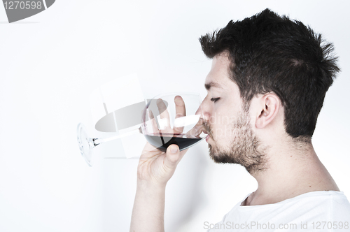 Image of Young man drinking wine