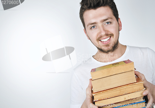 Image of Young happy man carrying books