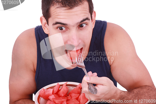 Image of Young man eating a fresh water melon. 