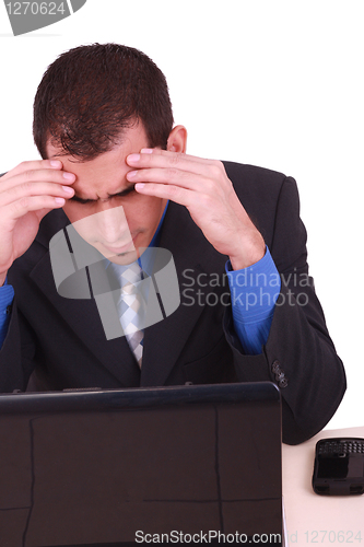 Image of Image of businessman touching his head while looking at monitor 