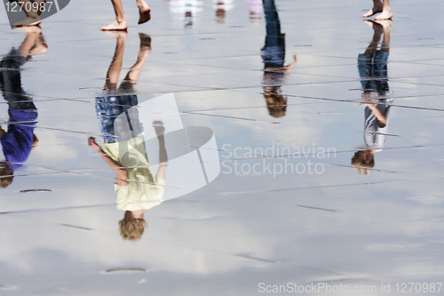 Image of Reflections of teens walking in the water.