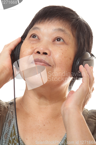 Image of Senior woman listening to music with headphones 