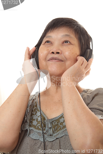 Image of Senior woman listening to music with headphones 