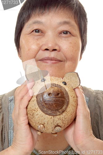 Image of woman putting coins in small piggy bank. Selective focus, Copy s