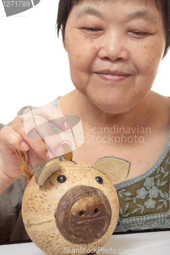 Image of woman putting coins in small piggy bank. Selective focus, Copy s