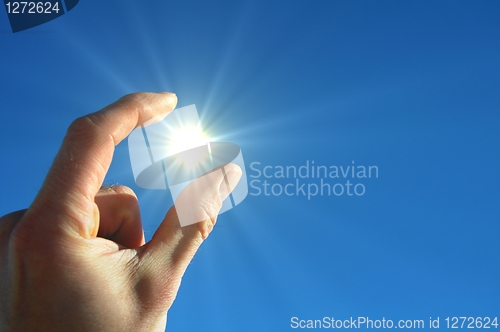 Image of hand sun and blue sky