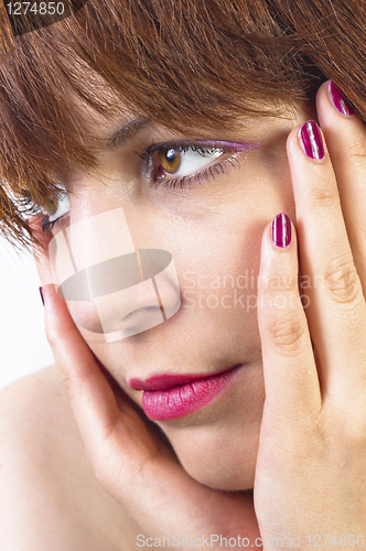 Image of Young woman holding her face