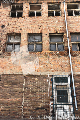 Image of Angle shot of an abandoned industrial building with brick wall