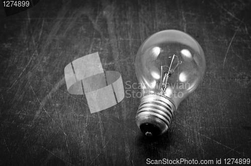 Image of Light bulb on wooden plate in black and white