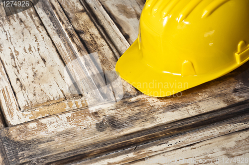 Image of Yellow helmet on burnt wooden log