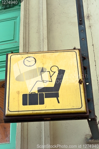 Image of Sit and wait sign in a train station