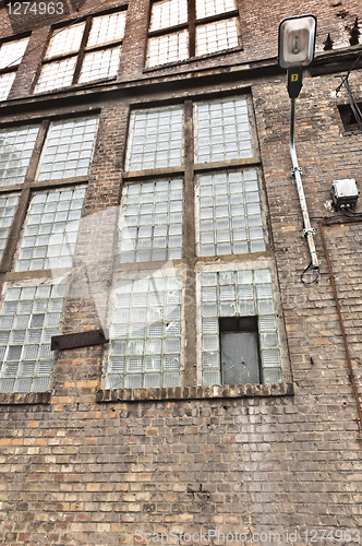 Image of Angle shot of an abandoned industrial building with brick wall