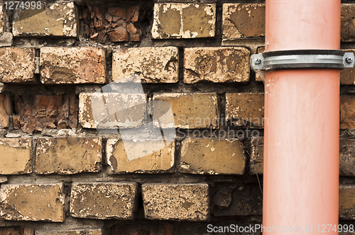 Image of Drain pipe against brick wall