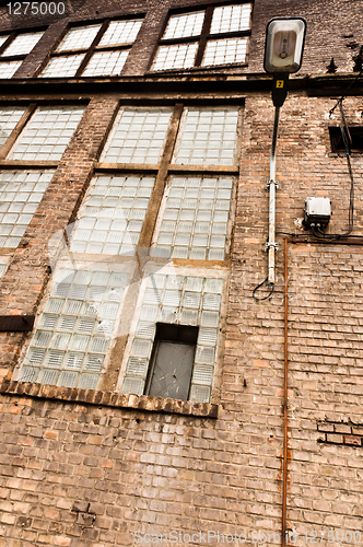 Image of Angle shot of an abandoned industrial building with brick wall