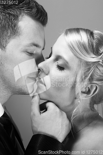 Image of young couple in wedding wear kissing