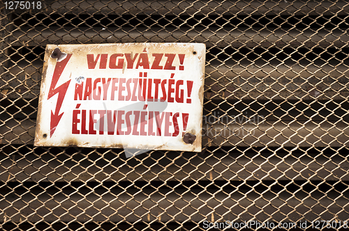 Image of High voltage sign on rusty fence