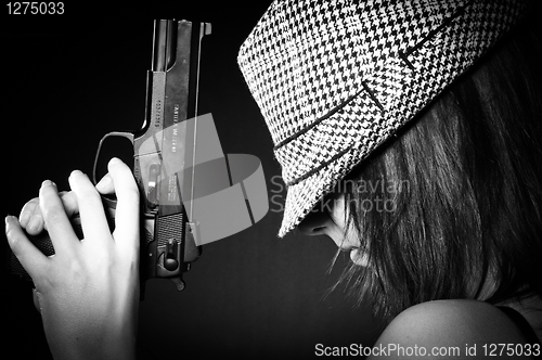 Image of Girl in hat with a big pistol