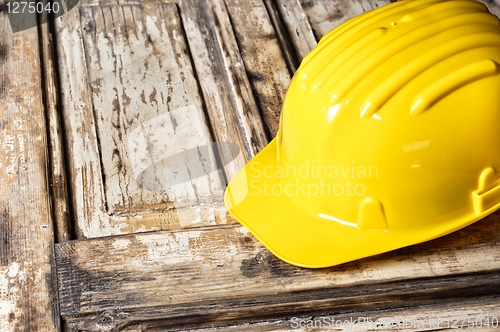 Image of Yellow helmet on burnt wooden log