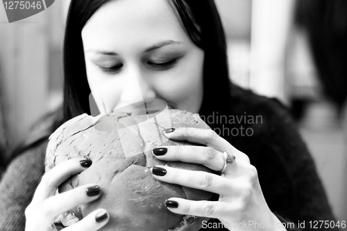 Image of Young woman eating hamburger