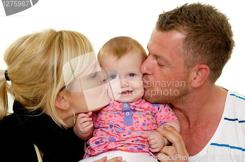 Image of Mother and father are kissing baby