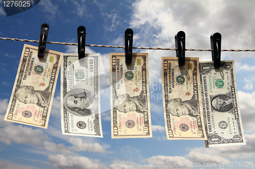 Image of paper dollars are drying on rope