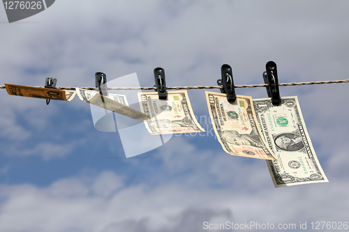 Image of paper dollars are drying on rope