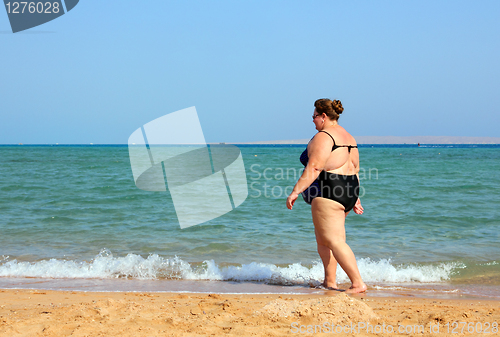 Image of overweight woman walking on beach