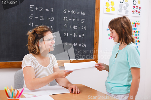 Image of Schoolgirl giving or receiving math test paper