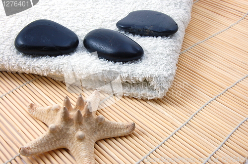 Image of foldet white bath towel and zen stones