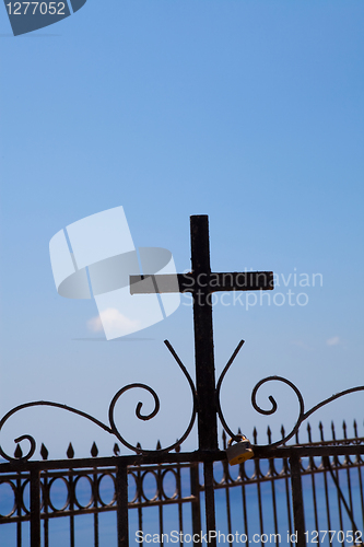 Image of Metal cross on a fence in Thira, Santorini, Greece