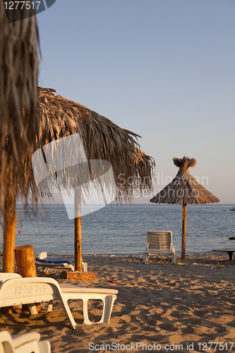 Image of beach with palms umbrella and chairs