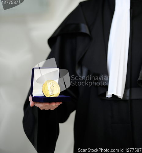 Image of Lawyer wearing a robe holdong a a justice meda