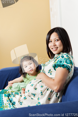 Image of Pregnant Asian mother and her daughter