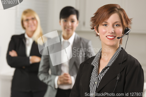 Image of Pretty Red Haired Businesswoman with Headset and Colleagues