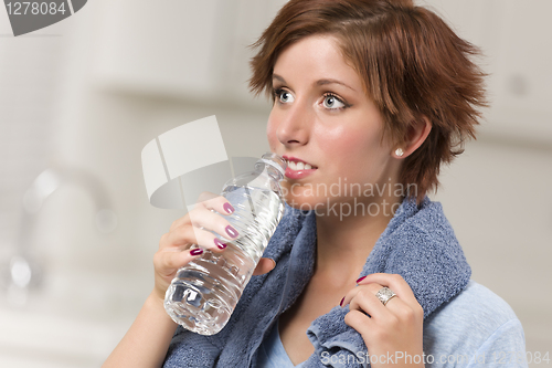 Image of Pretty Red Haired Woman with Towel Drinking From Water Bottle