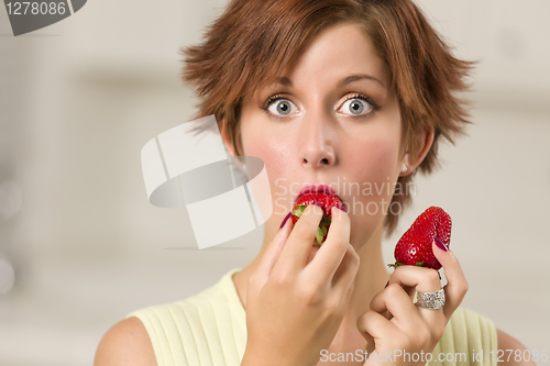 Image of Pretty Wide-eyed Red Haired Woman Biting Strawberry