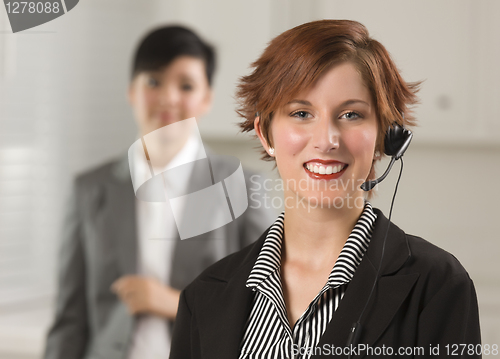 Image of Pretty Red Haired Businesswoman with Headset in Office