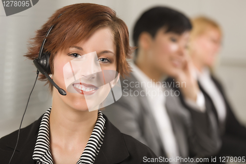 Image of Pretty Red Haired Businesswoman with Headset and Colleagues