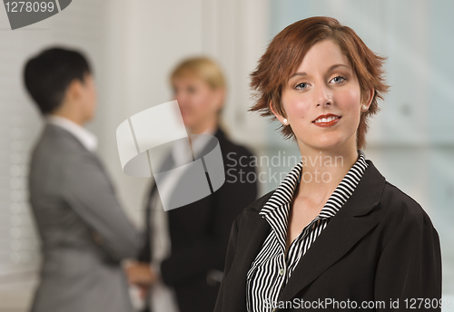 Image of Pretty Red Haired Businesswoman with Colleagues Behind