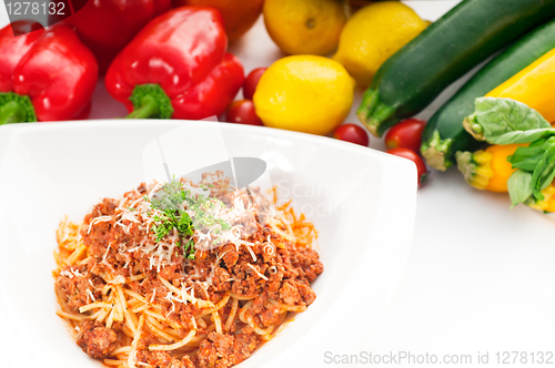 Image of spaghetti with bolognese sauce and fresh vegetables on backgroun